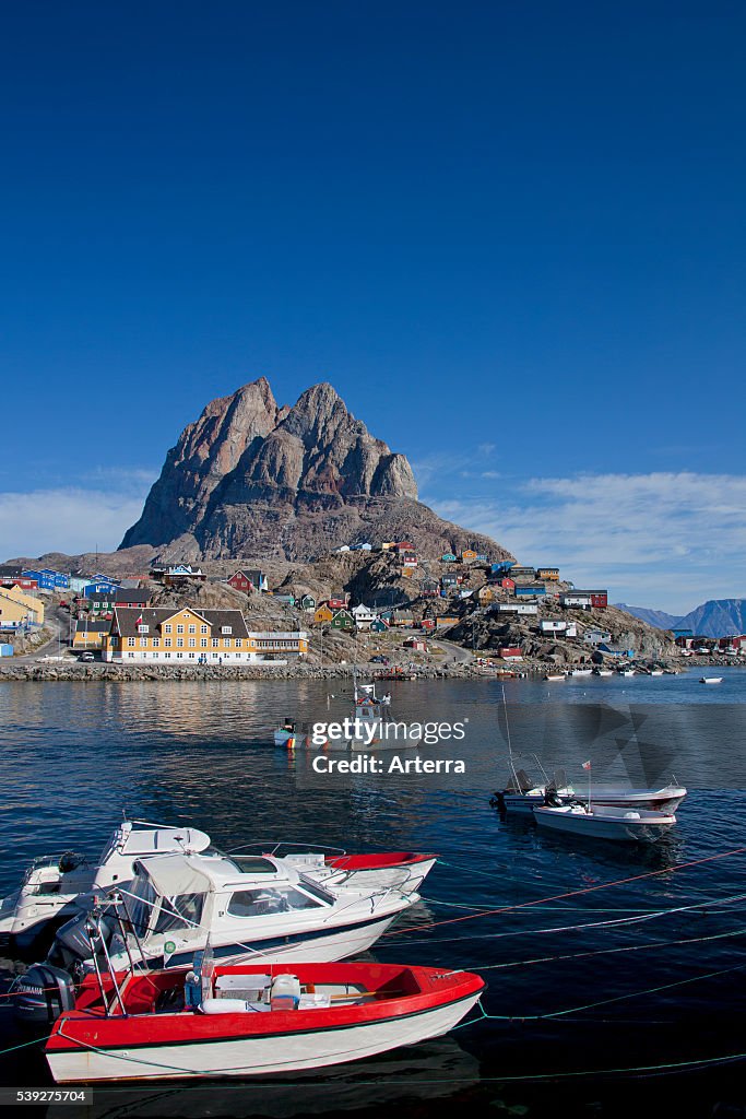 Uummannaq village with colourful houses and fishing boats in front of Heart Mountain