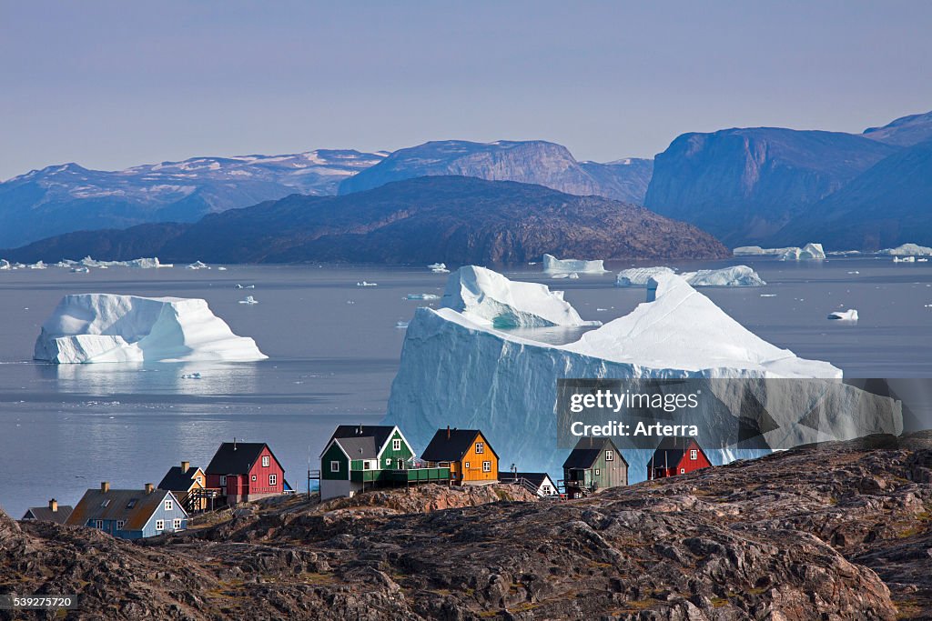 Uummannaq village with colourful houses and icebergs in the fjord