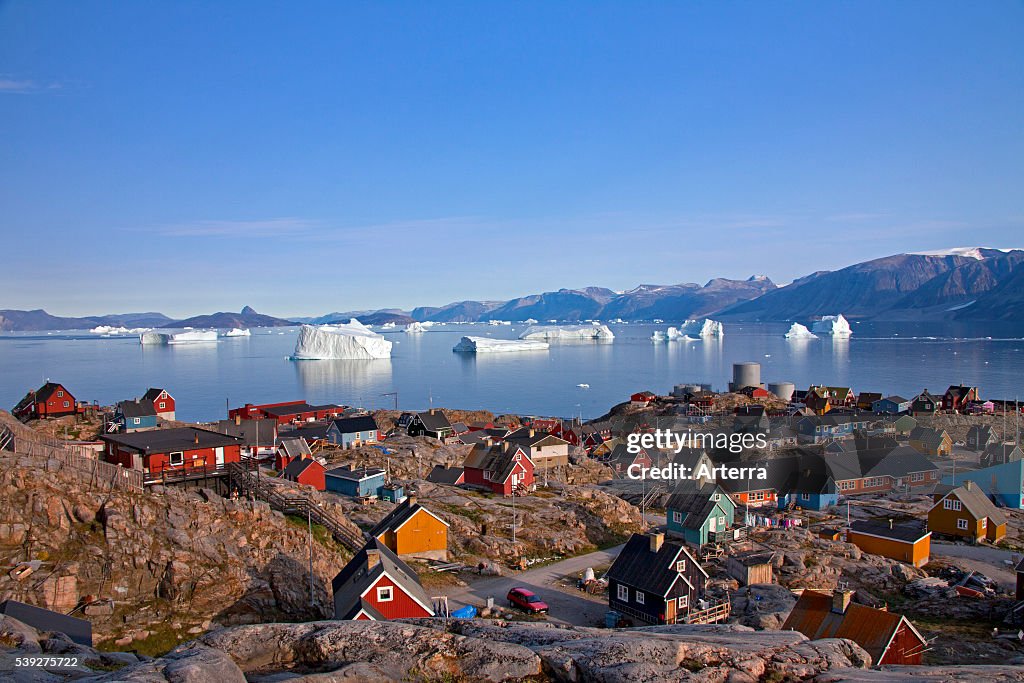 Uummannaq village with colourful houses and icebergs in the fjord