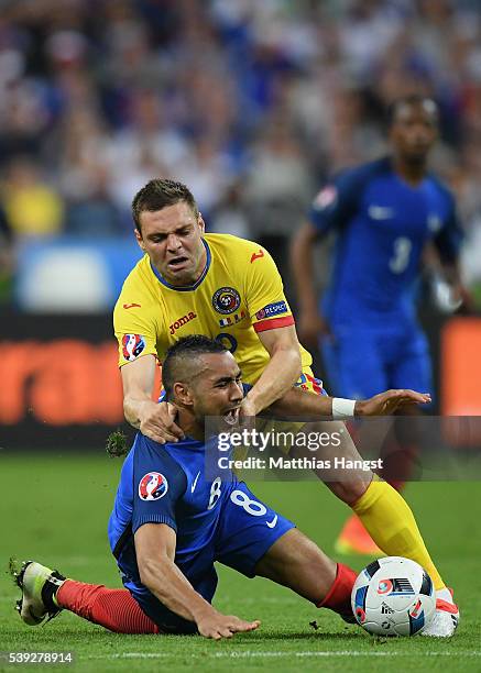 Dimitri Payet of France is chellenged by Adrian Popa of Romania during the UEFA Euro 2016 Group A match between France and Romania at Stade de France...