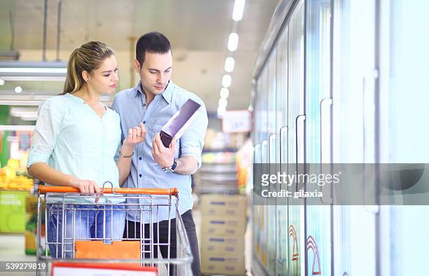 couple buying frozen food in supermarket. - frozen food stock pictures, royalty-free photos & images
