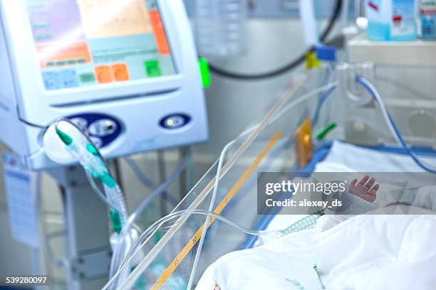 infant lying in incubator for newborns - icu stockfoto's en -beelden