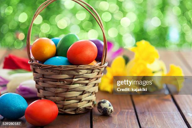 bunte easter eggs in basket - osternest stock-fotos und bilder