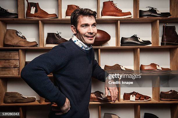 man working in a small business retailer at shoe store - schoenenwinkel stockfoto's en -beelden