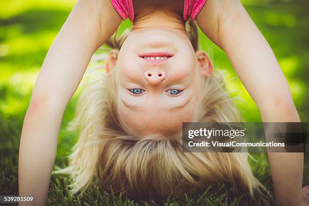 niña de pie boca abajo. - hacer el pino fotografías e imágenes de stock