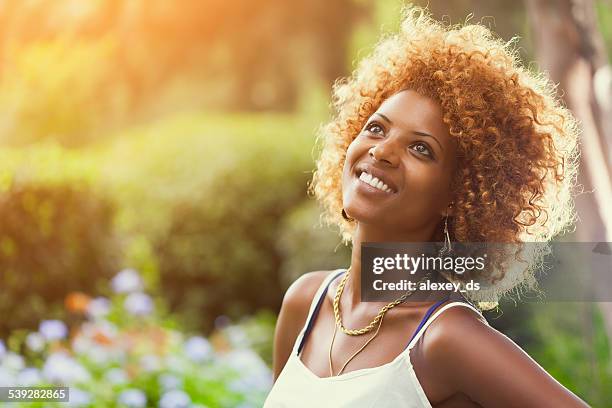 smiling african woman in sunshine outdoors profile portrait - curly hair profile stock pictures, royalty-free photos & images