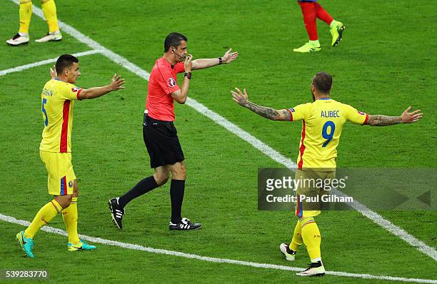 Referee Viktor Kassai points the penalty spot after Patrice Evra of France fouling Nicolae Stanciu of Romania in the area during the UEFA Euro 2016...