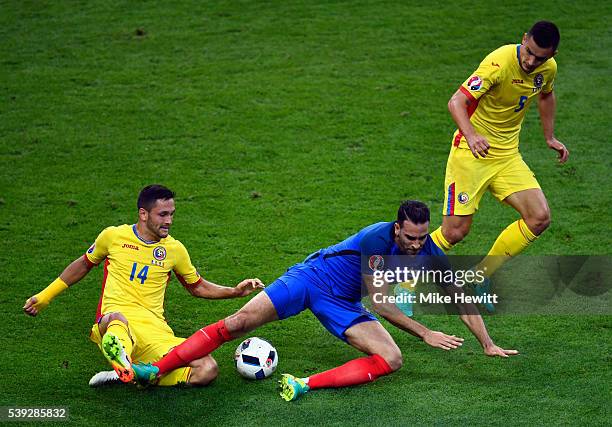 Adil Rami of France is tackled by Florin Andone of Romania during the UEFA Euro 2016 Group A match between France and Romania at Stade de France on...