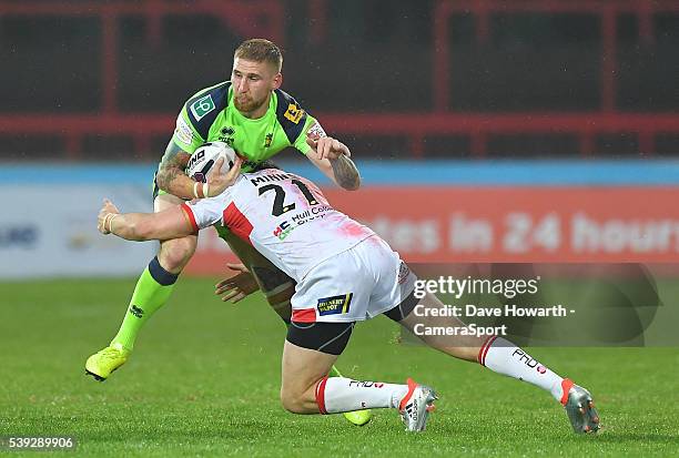 Sam Tomkins of Wigan Warriors is tackled by Thomas Minns of Hull Kingston Rovers during the First Utility Super League Round 18 match between Hull...