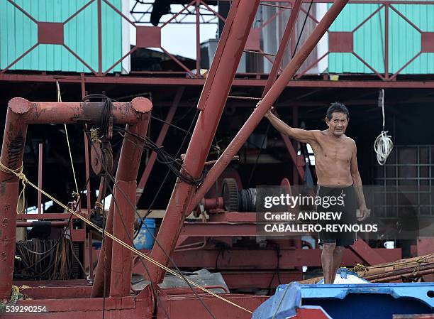 Guyanese indigenous gold miner looks on from a mining barge on the Mazaruni river near the town of Bartica, Guyana on June 6, 2016. Bartica is a town...