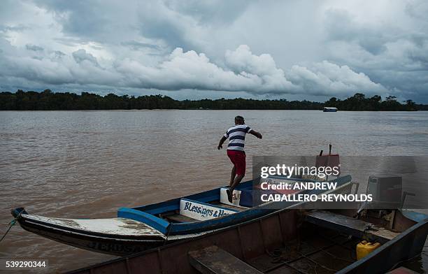 Man gets back onto his boat after docking at a gold mining barge on the Mazaruni river near the town of Bartica, Guyana on June 6, 2016. Bartica is a...