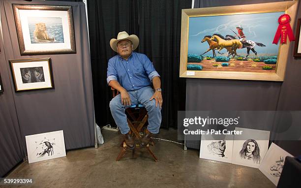 Norris Chee, a Navajo, sits in his booth at the Red Earth Native American Festival, Friday, June 10, 2016 in Oklahoma City, waiting to sell his art...