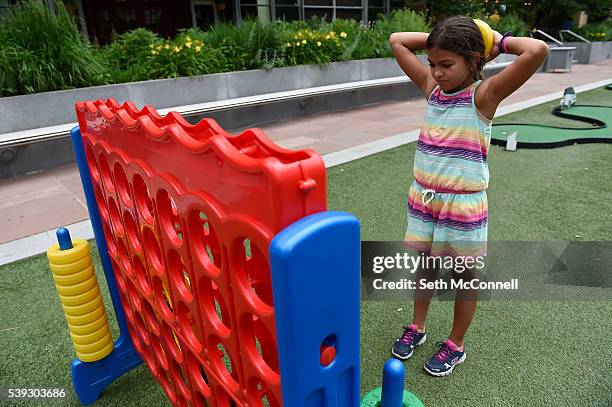 Sofia Samalot contemplates her next move while playing connect four with her dad, Omar Samalot, at Skyline Park in Denver, Colorado on June 10, 2016....