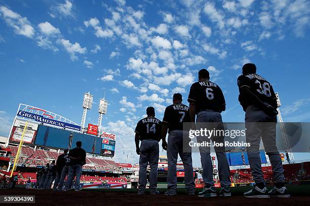 Oakland Athletics players and coaches stand during the national anthem prior to the game against the Cincinnati Reds at Great American Ball Park on...