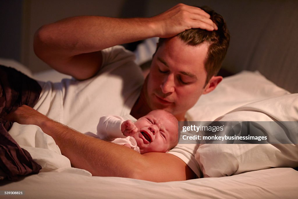 Pais Deitado na cama a chorar a filha bebê