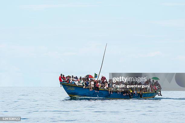 crowded refugee boat on lake tanganyika - refugee silhouette stock pictures, royalty-free photos & images