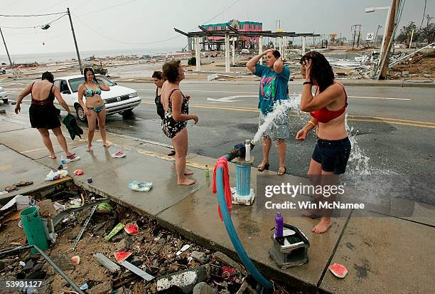 Women bathe in an open fire hydrant September 1, 2005 in Biloxi, Mississippi. Residents are still without electricity, water or communications for a...