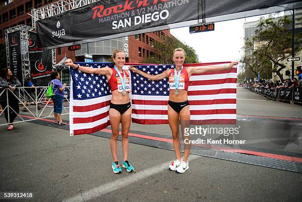 Time Olympian Shalane Flanagan, right, and 2-time Olympian Amy Cragg, left, pose with the Stars and Stripes flag after both set personal best times...