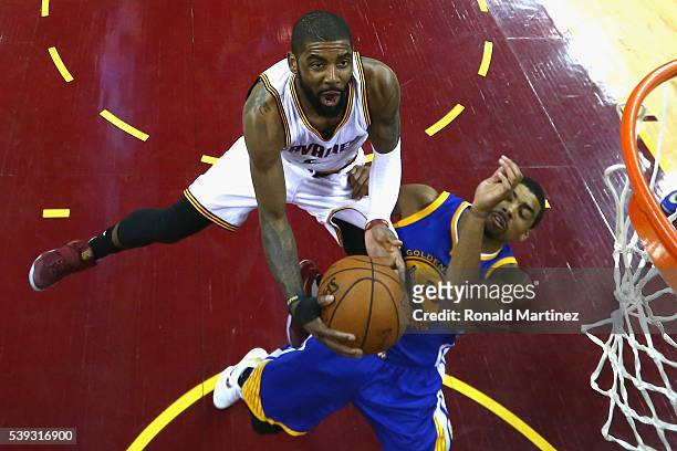 Kyrie Irving of the Cleveland Cavaliers drives to the basket against James Michael McAdoo of the Golden State Warriors during the second half in Game...