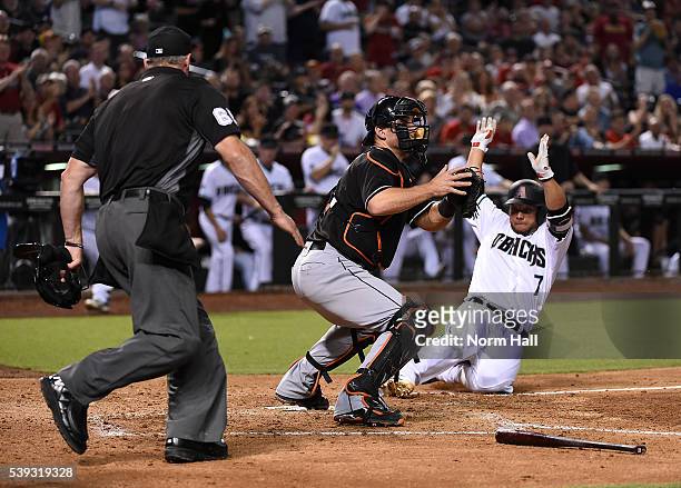 Welington Castillo of the Arizona Diamondbacks safely slides into home on a double by teammate Jake Lamb during the fifth inning as catcher Jeff...