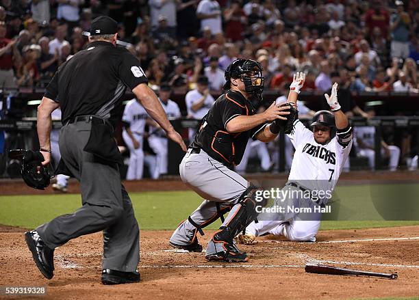 Welington Castillo of the Arizona Diamondbacks safely slides into home on a double by teammate Jake Lamb during the fifth inning as catcher Jeff...