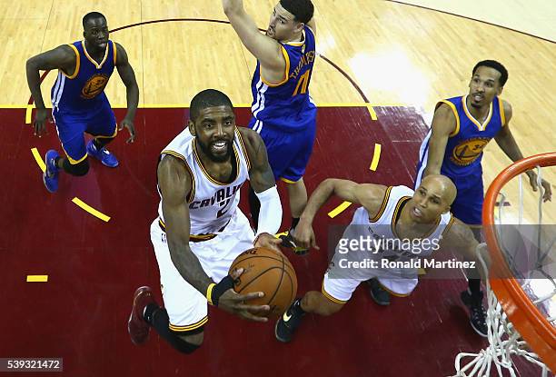 Kyrie Irving of the Cleveland Cavaliers takes a shot in front of Draymond Green, Klay Thompson, Shaun Livingston of the Golden State Warriors and...