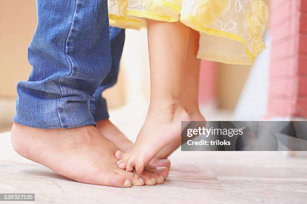 father dancing with his daughter - baby pants with feet stock pictures, royalty-free photos & images