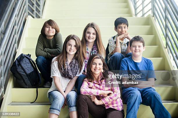 giovani studenti seduti insieme sulla scala - educazione secondaria di scuola media foto e immagini stock