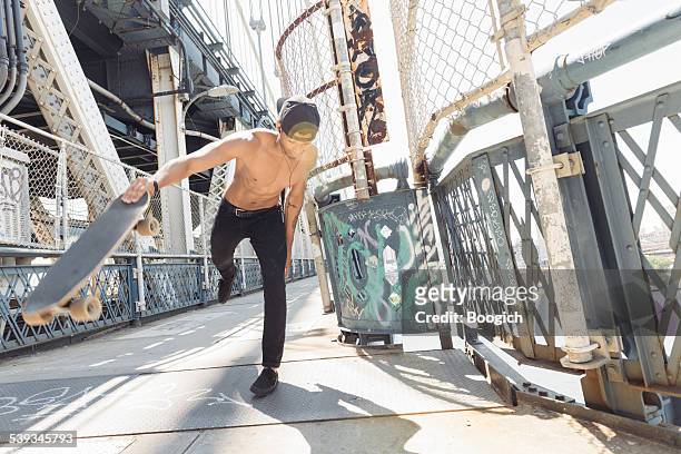 nyc skateboarding mann überqueren sie die manhattan bridge nahverkehr in der stadt - skate fail stock-fotos und bilder