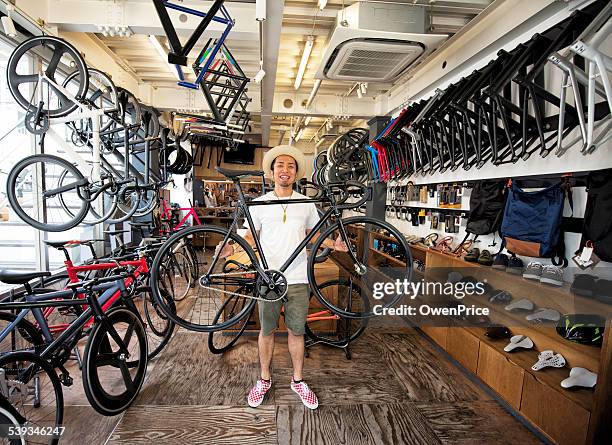 de tóquio loja proprietário segurando uma roda de bicicleta de fixação. - loja de bicicletas imagens e fotografias de stock