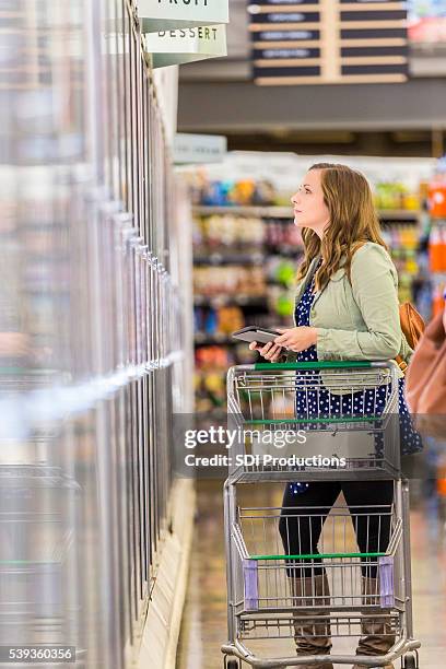 beautiful woman grocery shopping with tablet - mejeriavdelning bildbanksfoton och bilder