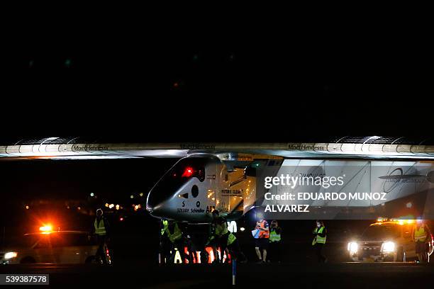 Team members of The Solar Impulse 2 aircraft push the plane after being successfully landed by Swiss pilot Andre Borschberg at JFK International...