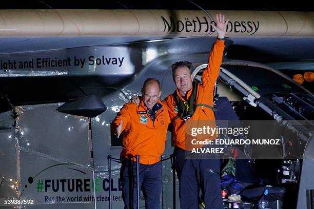 Swiss pilot Andre Borschberg waves to the crowd next to Swiss pilot Bertrand Piccard after the Solar Impulse 2 aircraft successfully landed at JFK...