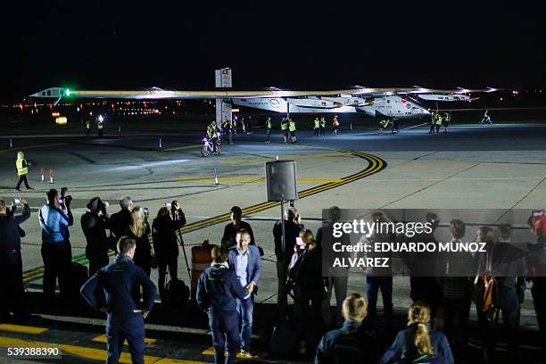 People watch the arrival of the Solar Impulse 2 aircraft following its successful landing at JFK International Airport on June 11, 2016 in Queens,...