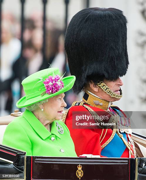 Queen Elizabeth II and Prince Philip, Duke of Edinburgh ride by carriage during the Trooping the Colour, this year marking the Queen's official 90th...