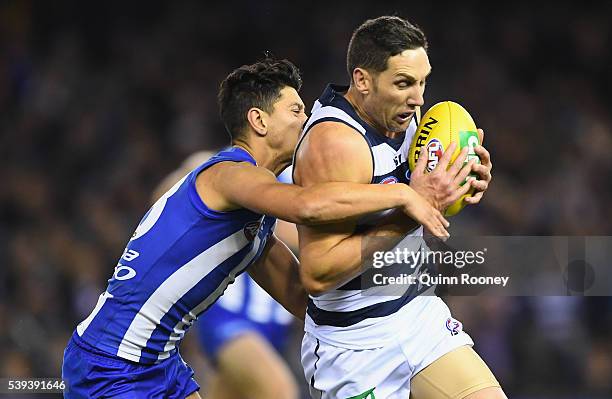 Harry Taylor of the Cats is tackled by Robin Nahas of the Kangaroos during the round 12 AFL match between the Geelong Cats and the North Melbourne...