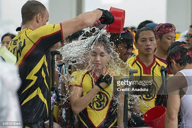 Competitor pours a bucket of water to his partner during the Hong Kong Dragon Boat Festival held at Central Harbourfront in Hong Kong on June 11,...
