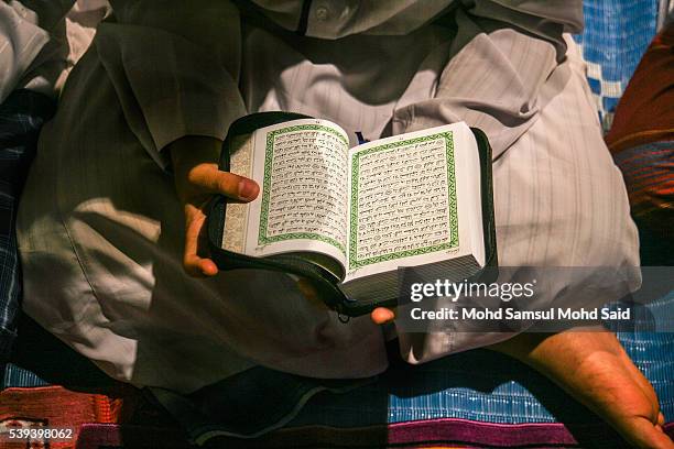 Muslim Islamic students read the Koran inside the Sultan Abdul Samad building during the holy month of Ramadan at Dataran Merdeka on June 11, 2016 in...