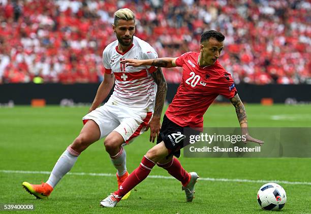 Ergys Kace of Albania controls the ball under pressure of Valon Behrami of Switzerland during the UEFA EURO 2016 Group A match between Albania and...