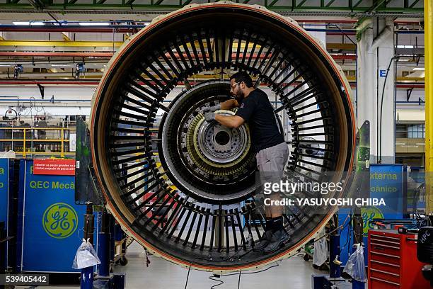 Man works with a jet engine at General Electric Celma, GE's aviation engine overhaul facility in Petropolis, Rio de Janeiro, Brazil on June 8, 2016....