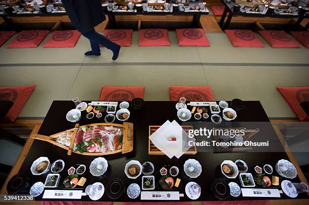 Plate of sashimi, slices of raw fish, is seen on a table inside a yakatabune, or traditional low barge style boat, operated by Mikawaya shipping...