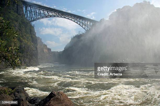 Bridge over the Zambezi river between Zambia and Zimbabwe, covered in spray of the Victoria falls, Southern Africa.
