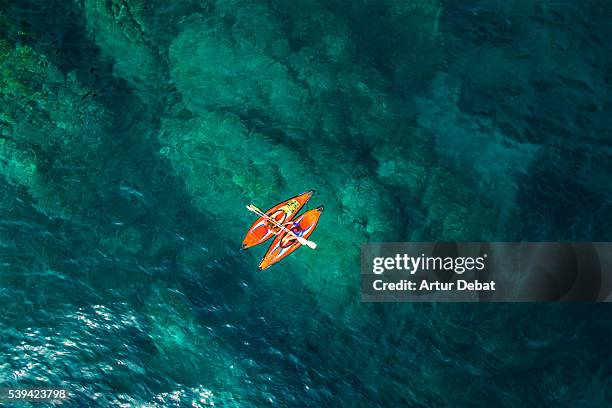 aerial picture of two girls practicing kayak in a paradise place of the costa brava beach with beautiful and transparent blue water on summertime. - beach no people stock pictures, royalty-free photos & images