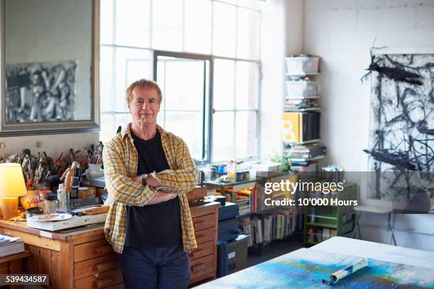 portrait of a mature male artist in his studio - plaid shirt stock pictures, royalty-free photos & images