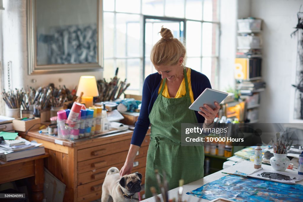 Female designer in studio holding digital tablet