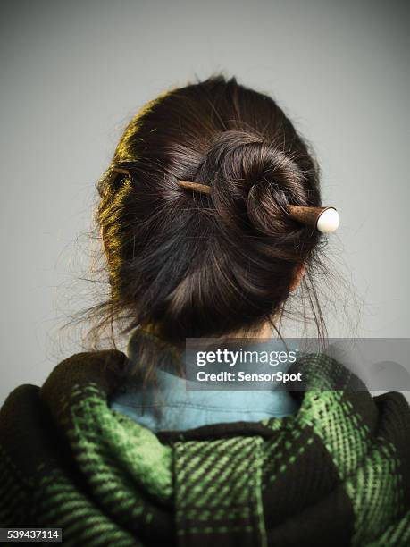 young woman with hair bun. - tying stock pictures, royalty-free photos & images