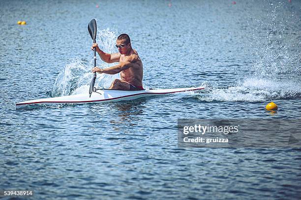 young muscular man during kayak sprint training on still water. - single scull stockfoto's en -beelden