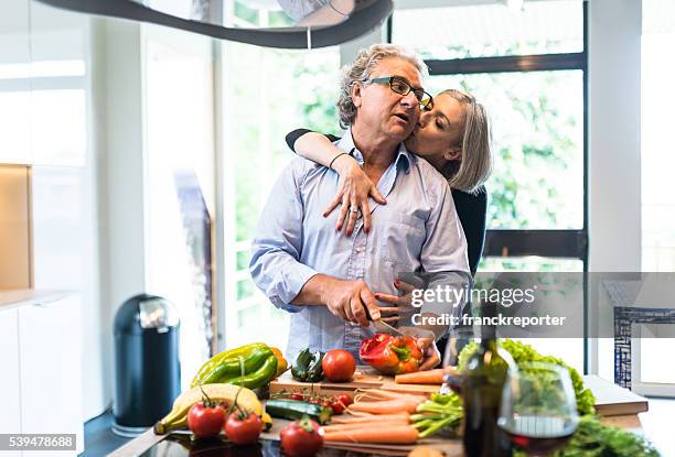 忙しい熟年カップルクッキングキッチンの - middle aged couple cooking ストックフォトと画像