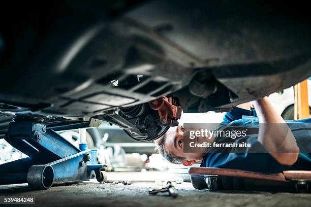 mécanicien travaillant sous voiture du véhicule - partie inférieure photos et images de collection