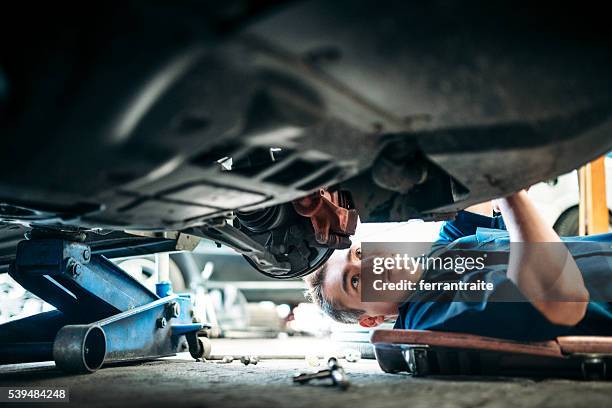 car mechanic working under vehicle - jacke stock pictures, royalty-free photos & images